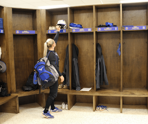 A senior softball player putting away her equipment for the last time.